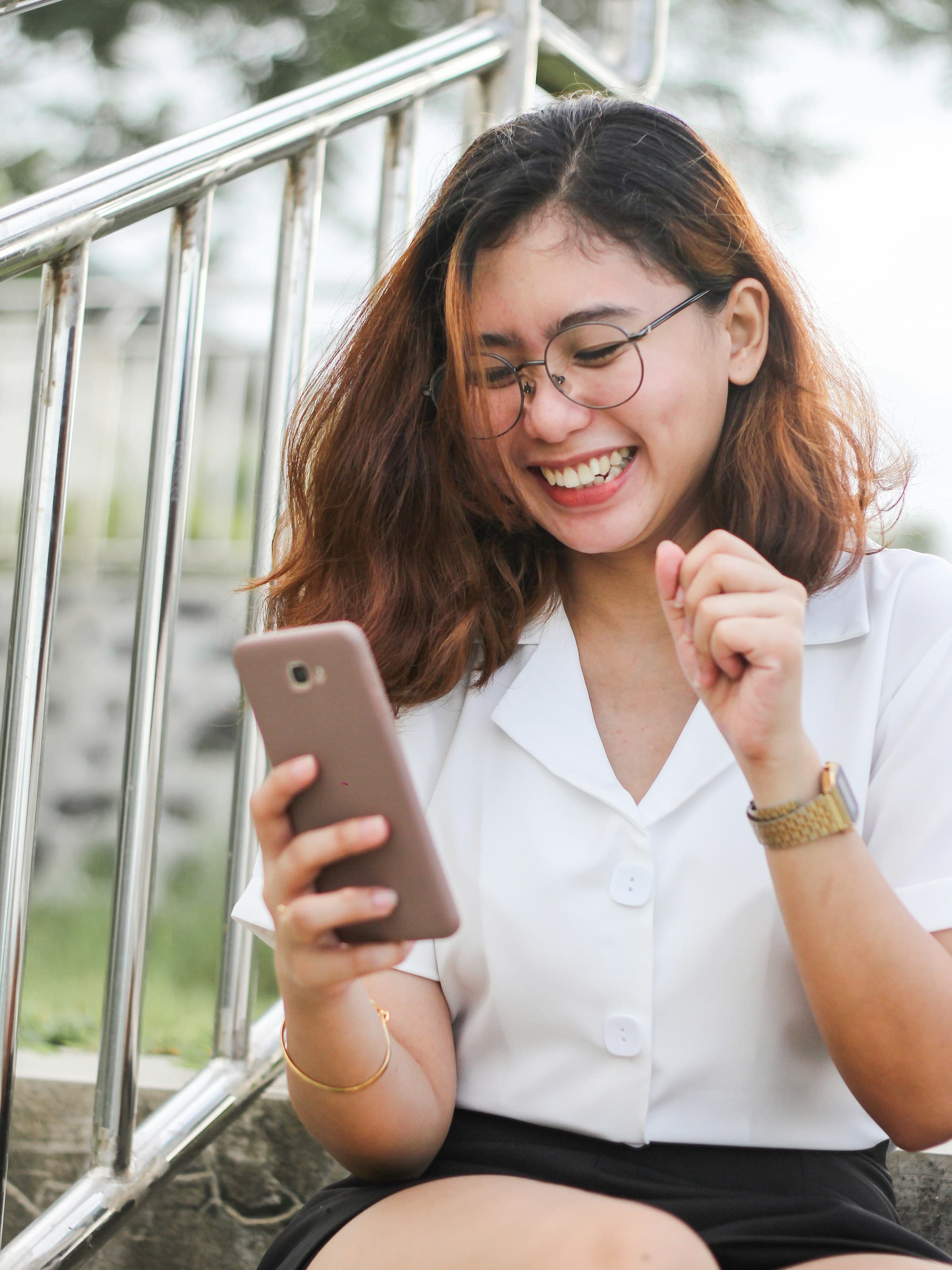 A woman laughing as she reads a message on her phone